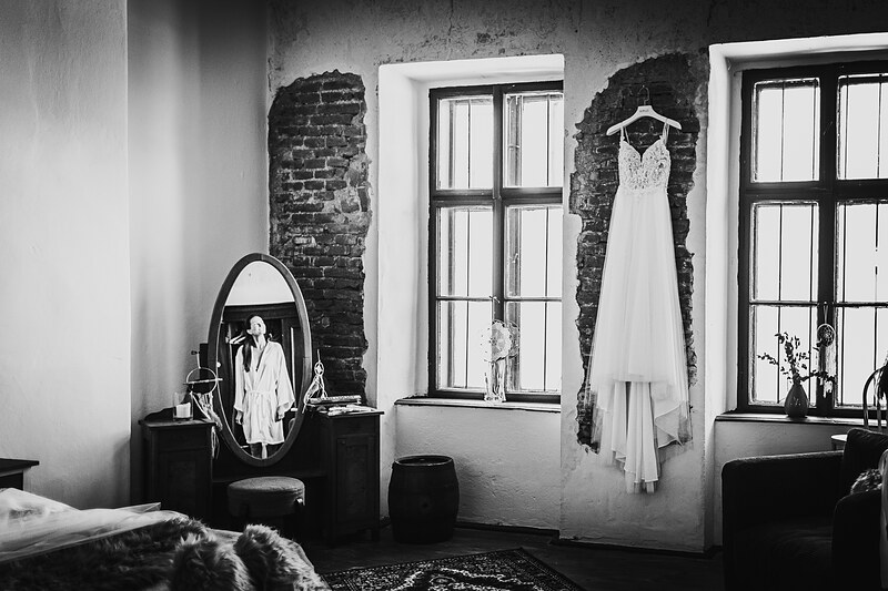 svadobné šaty na vešiaku, nevesta v zrkadle, čiernobiely interiér, tehlové steny, vysoké okná so svetlom, minimalistická spálňa. Hacienda Šišov.