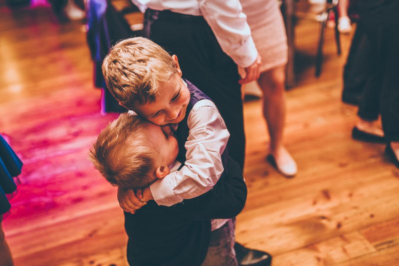 deti tancujú na svadbe, chlapci v spoločenskom oblečení, tanečný parket s farebným osvetlením, deti sa hrajú na recepcii, teplé oranžové a ružové svetlá, svadobná oslava s deťmi. Meridiana Resort, Bojnice.
