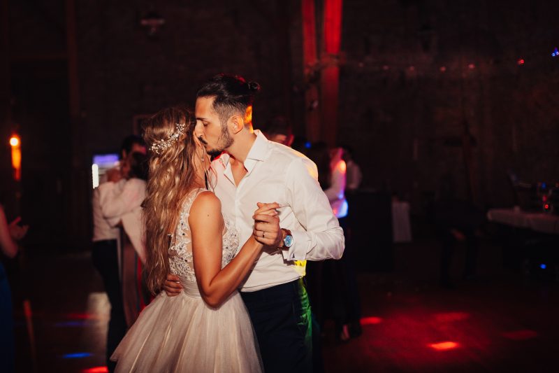 prvý tanec nevesty, ženích v bielej košeli, červené svetlo na parkete, pár tancujúci v tme, svadobný tanec s červeným osvetlením, nevesta v bielych šatách. Karolinenhof Farm, Hainburg.