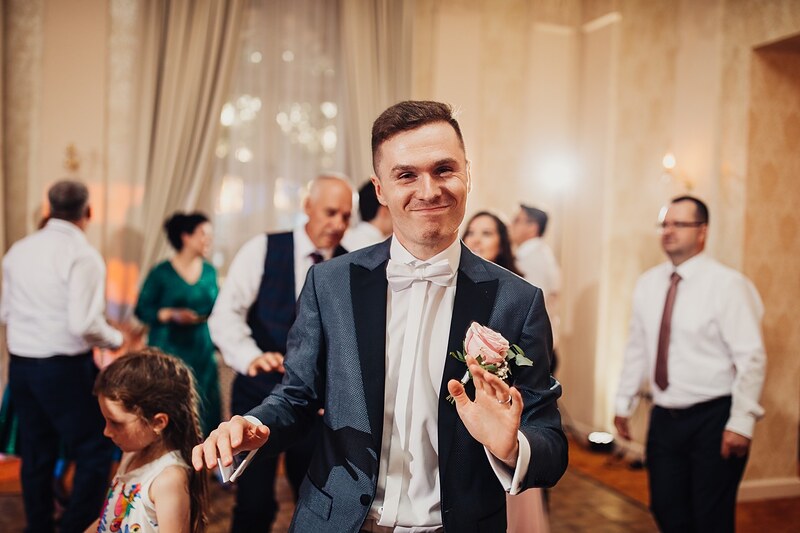ženích tancuje s dievčatkom v sále, hostia okolo, farebné svetlá. Kaštieľ Klobušice.