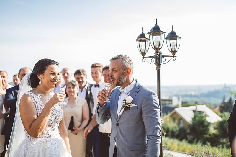 prípitok vonku po obrade, novomanželia s pohármi sektu, hostia okolo, výhľad na krajinu pod Zoborom. Hotel Zlatý Kľúčik, Nitra.