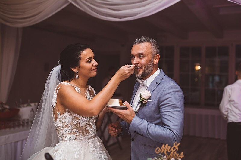 nevesta kŕmi ženícha kúskom torty, tylové drapérie v pozadí, nápis Mr & Mrs na stole. Hotel Zlatý Kľúčik, Nitra.