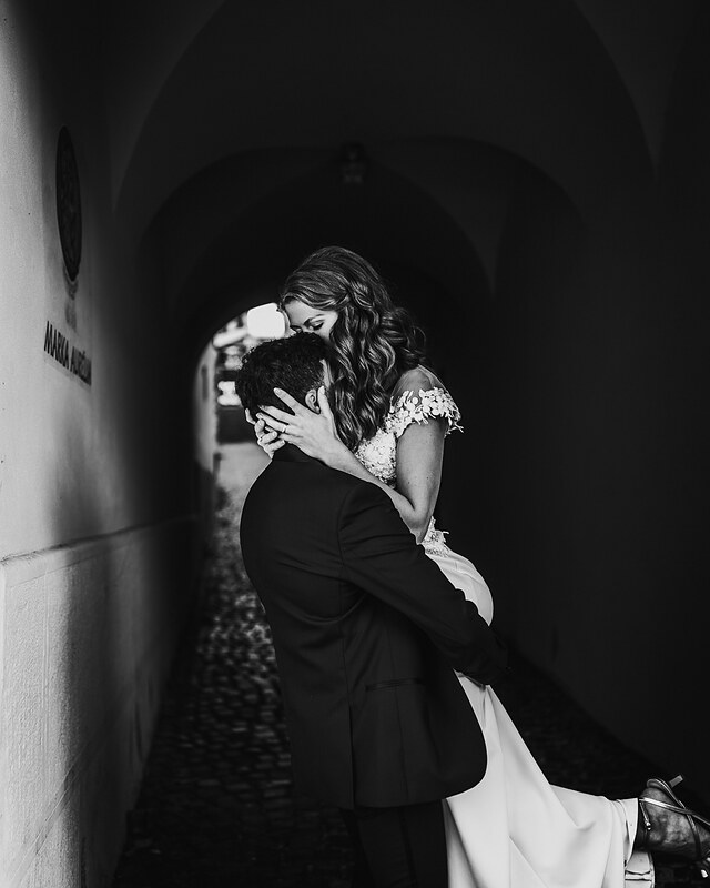 nevesta a ženích v tuneli, čiernobiely portrét, nežné objatie, svadobný pár v tme, lúč svetla na tvárach, romantický moment v kamennom priechode. Fatima, Trenčín.