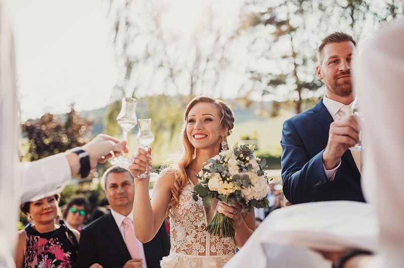prípitok na terase, nevesta s pohárom a kyticou, ženích vedľa, hostia okolo. Gazdovstvo Uhliská.
