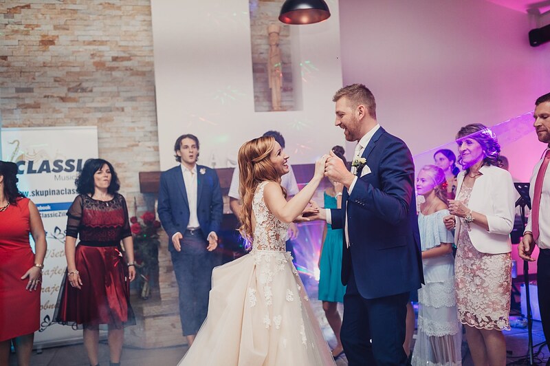 novomanželia tancujú zoči-voči, hostia v kruhu, farebné svetlá kapely. Gazdovstvo Uhliská.