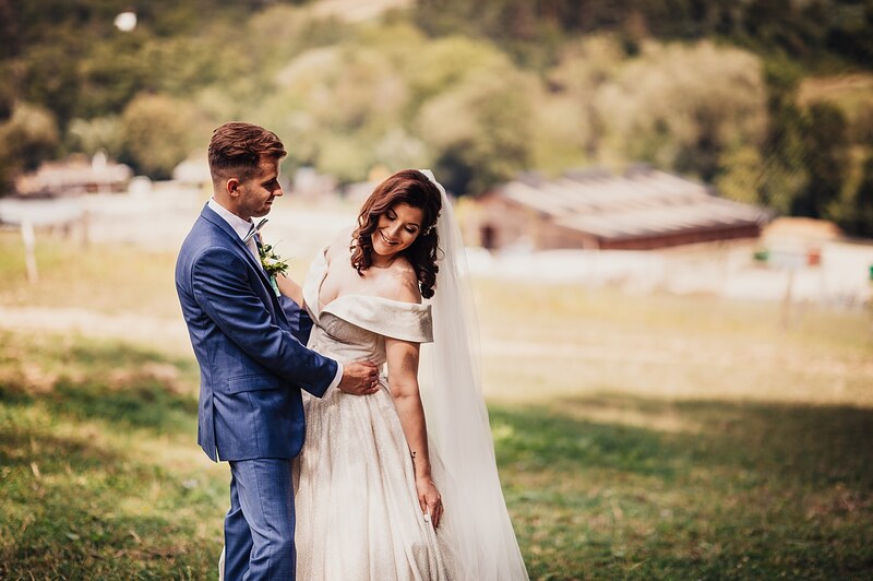novomanželia na pastvine, ženích drží nevestu okolo pása, hospodárske budovy v pozadí. Ranch 13, Nemšová.