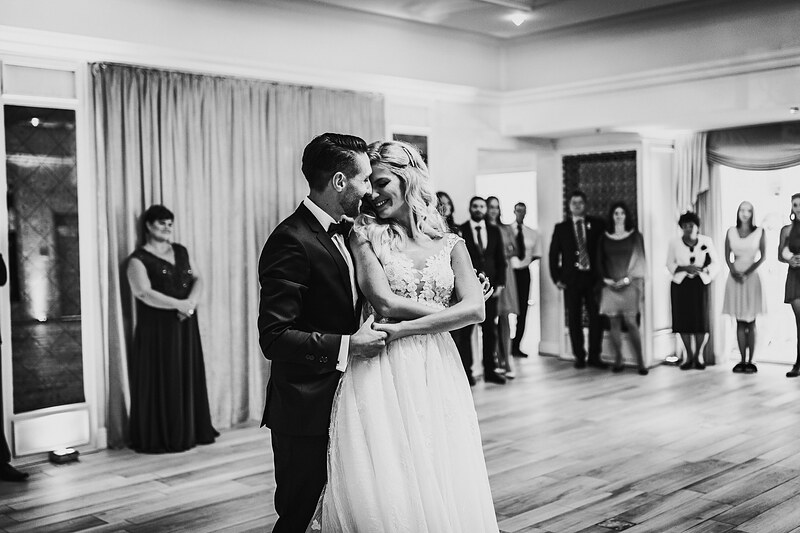prvý tanec novomanželov, ženích a nevesta tancujú, sála s hosťami, čiernobiely snímok svadby, hostia sledujú tanec, interiér so závesmi. Hotel Zlatý Kľúčik, Nitra.